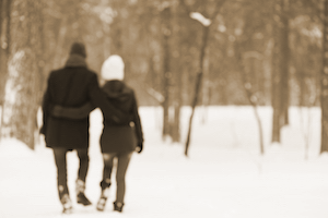 couple walks through forrest in winter